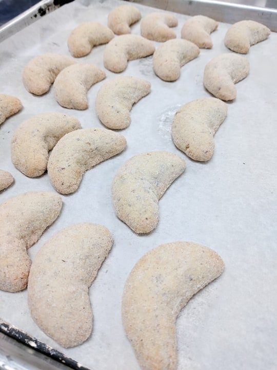 Almond crescent cookies on a baking sheet