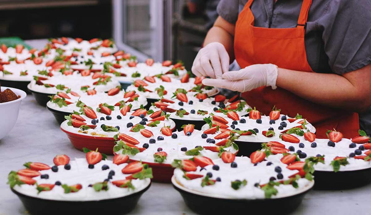 Chef decorating pies with fresh fruit