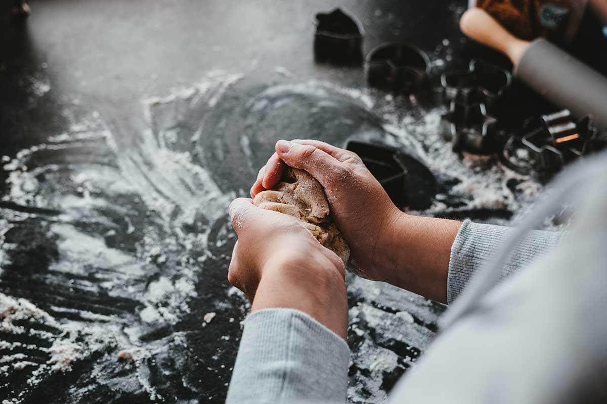 Hands shaping dough on a floured work surface