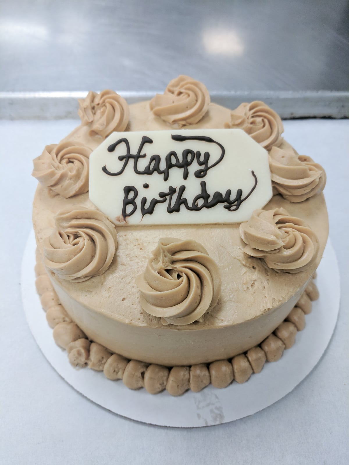 Genoise cake with coffee buttercream and a marzipan plaque that reads "Happy Birthday" 