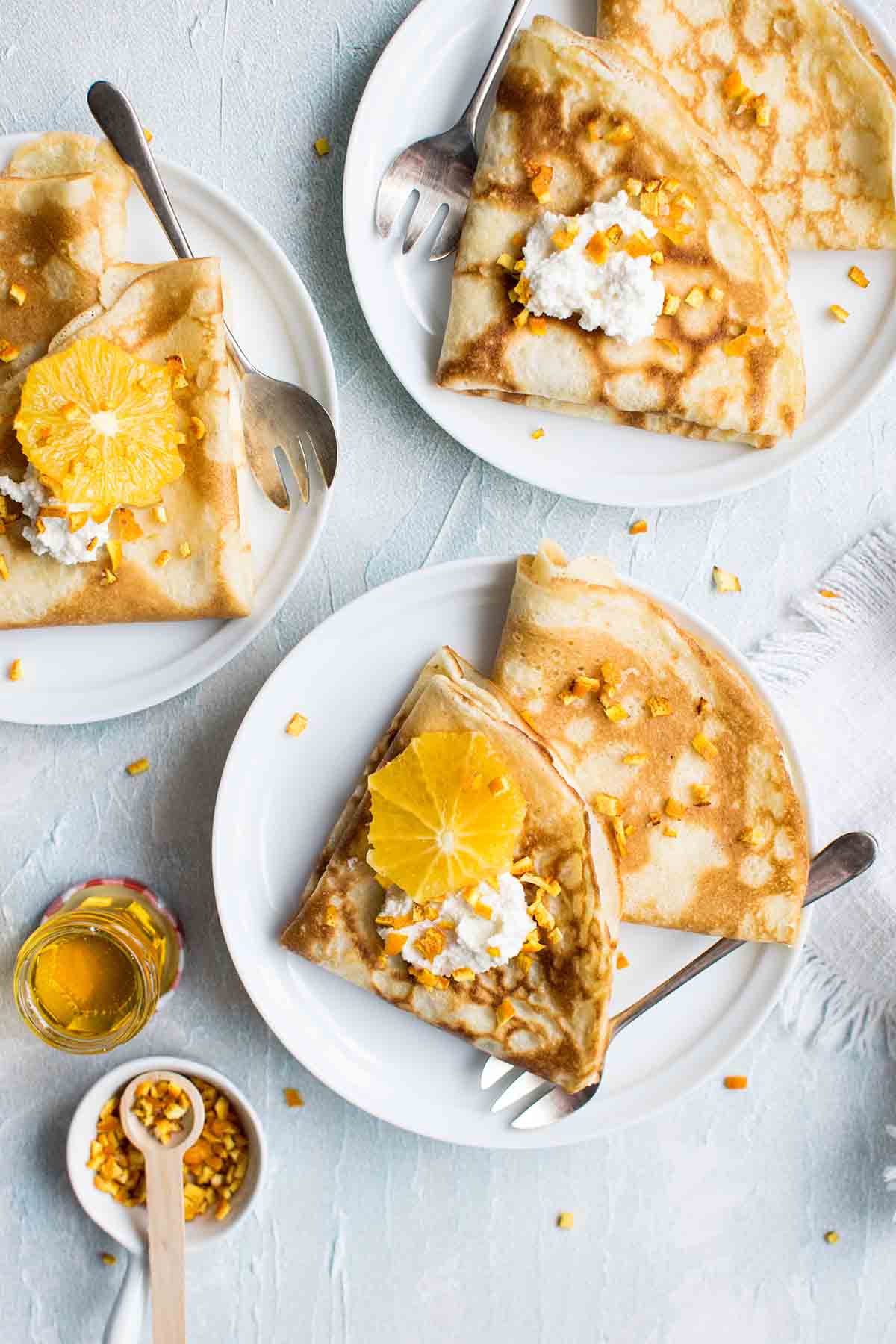 Three plates of crepes with citrus