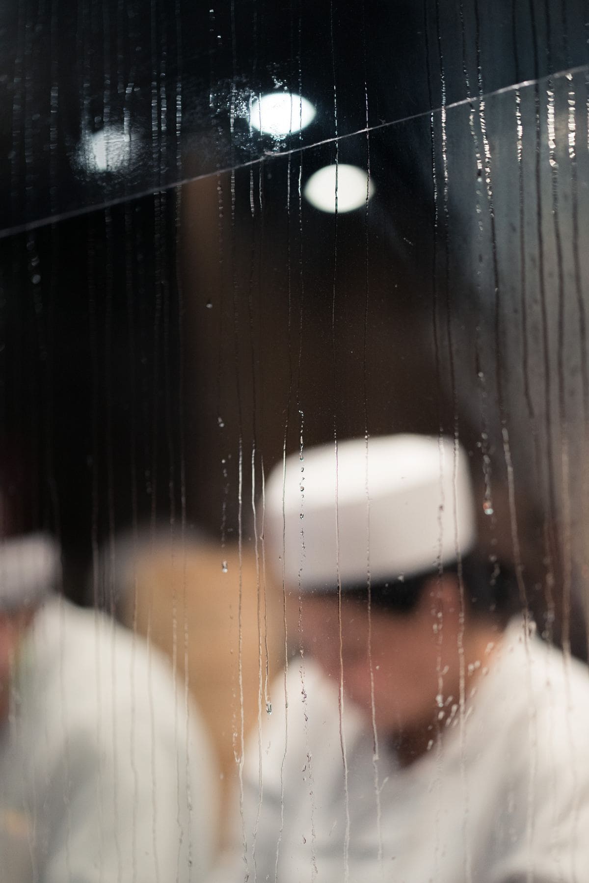 Chef working in front a window spattered with rain