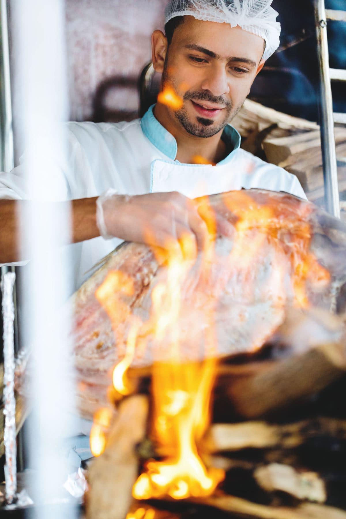 Cook grilling meat over an open flame