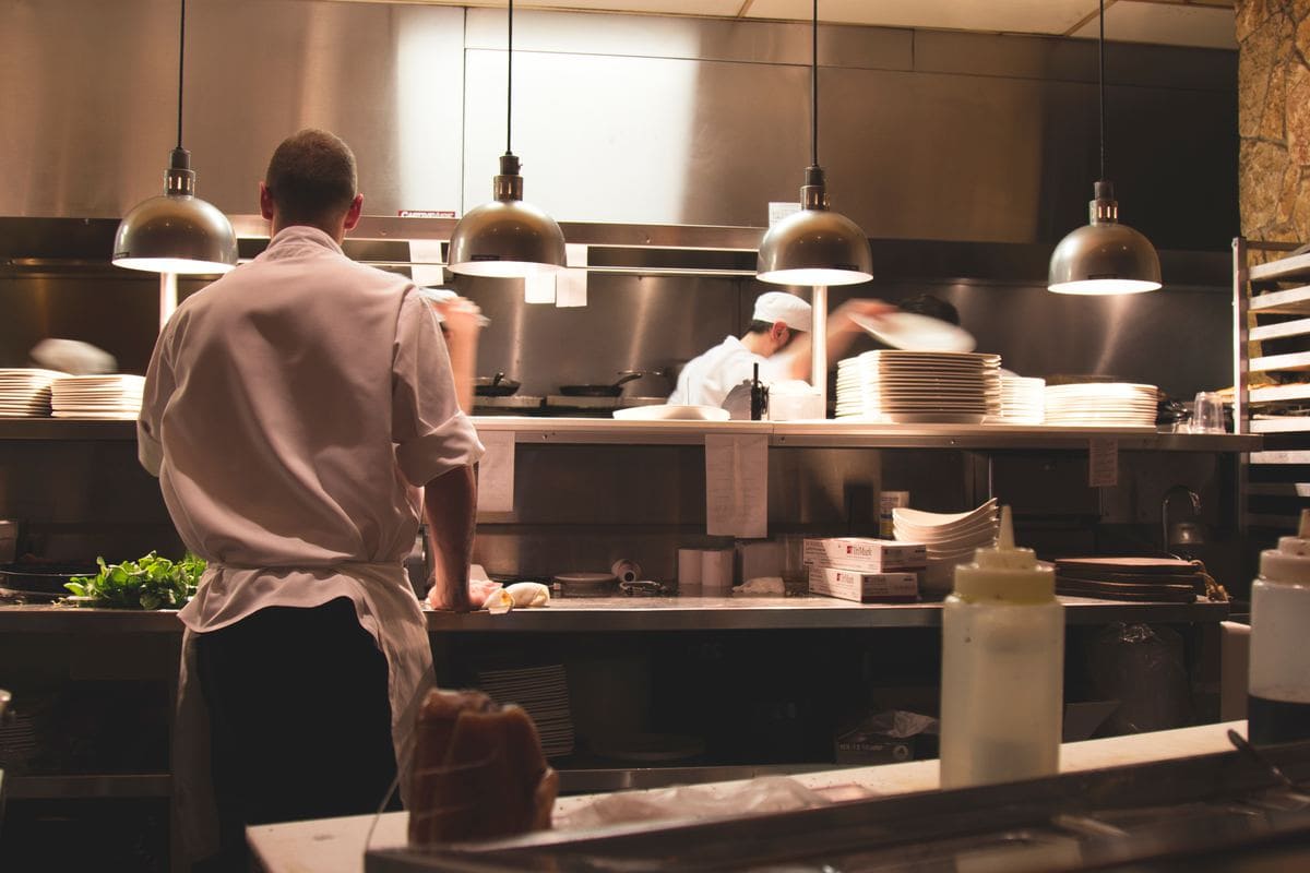 Various cooks standing on the line in a restaurant kitchen