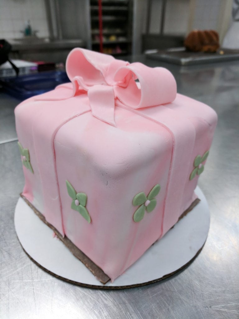 Pink gift box cake with green flowers