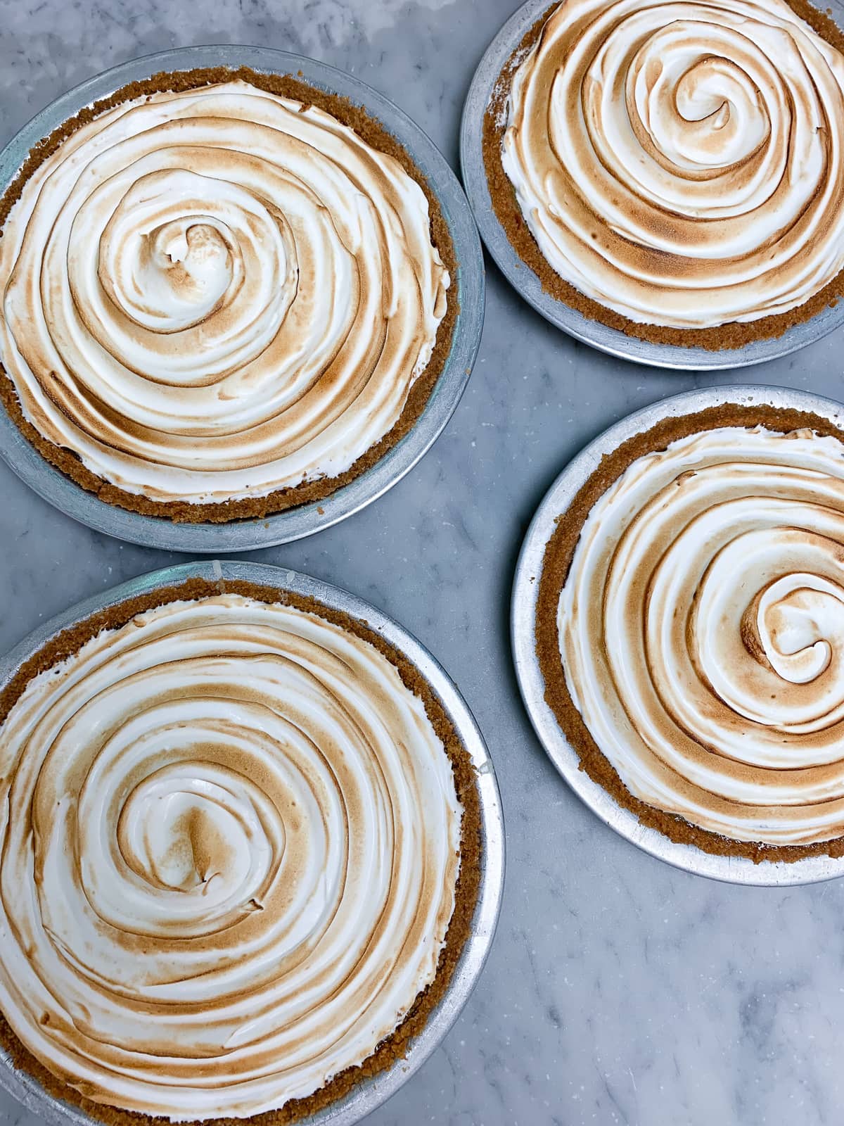 Four lemon meringue pies viewed from above 