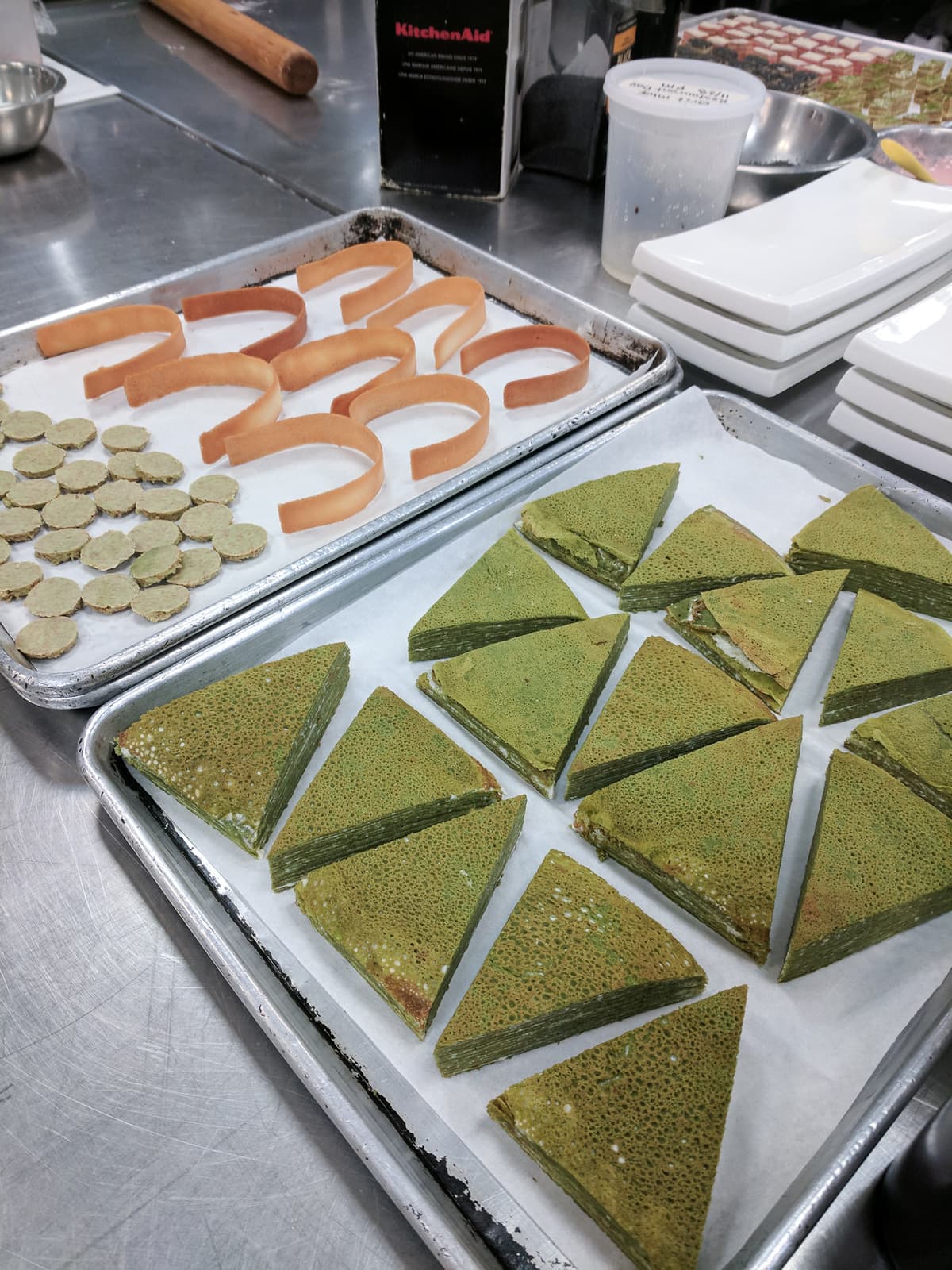 Slices of crepe cake and tuile laid on sheet trays