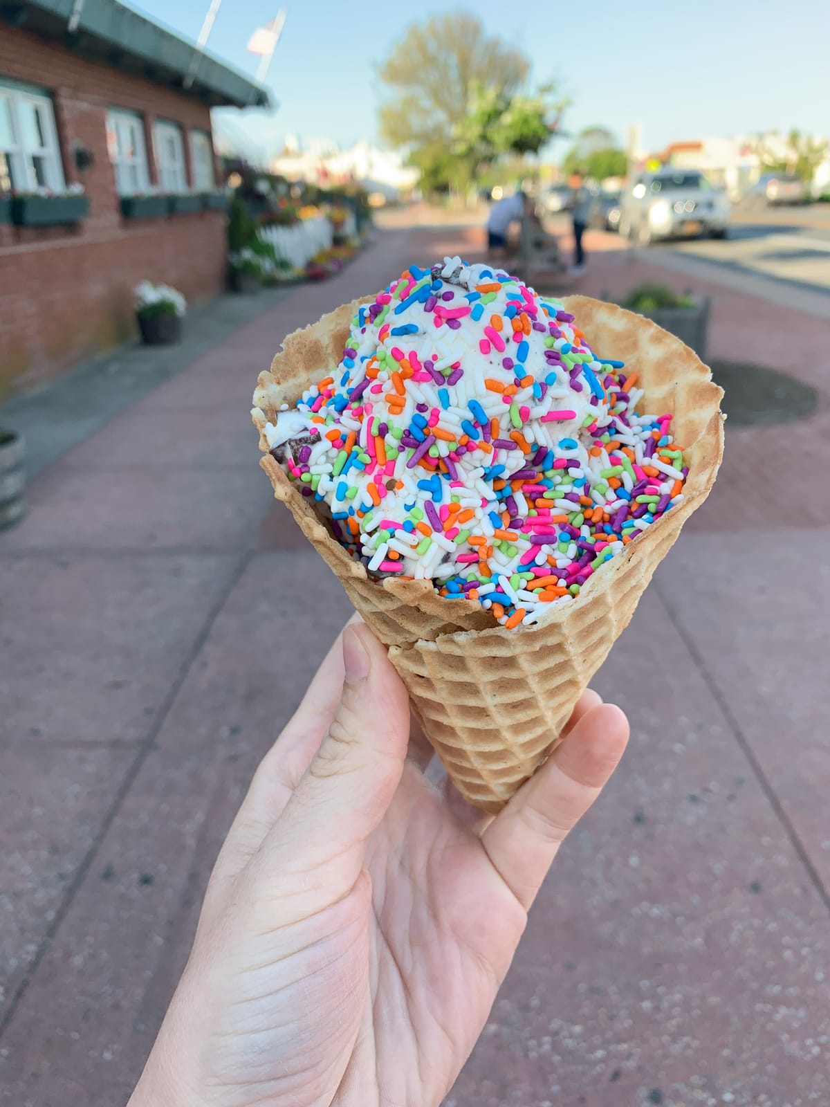 Shot of a hand holding an ice cream cone covered with sprinkles