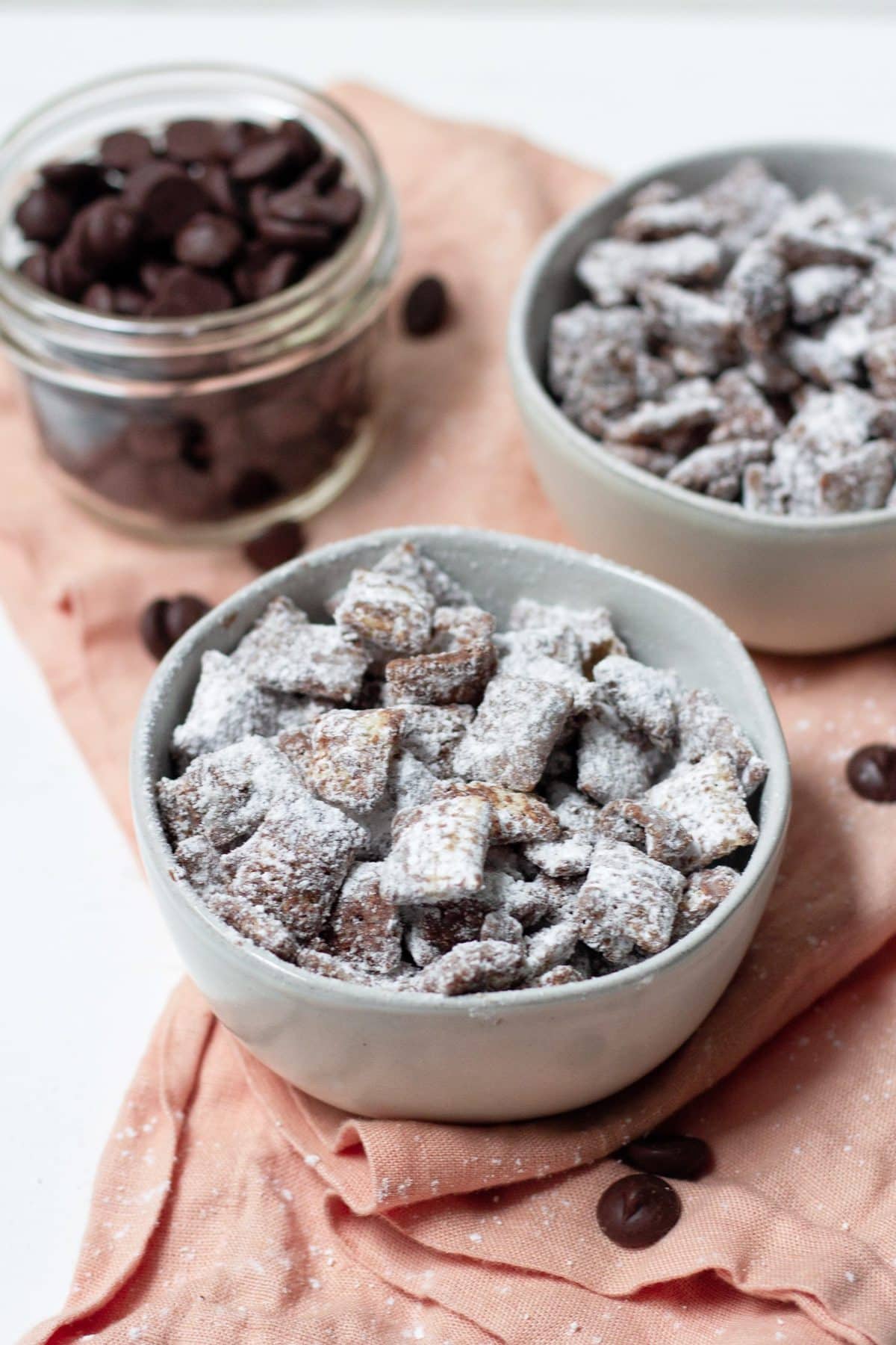 Two bowls of vegan puppy chow on a pink napkin