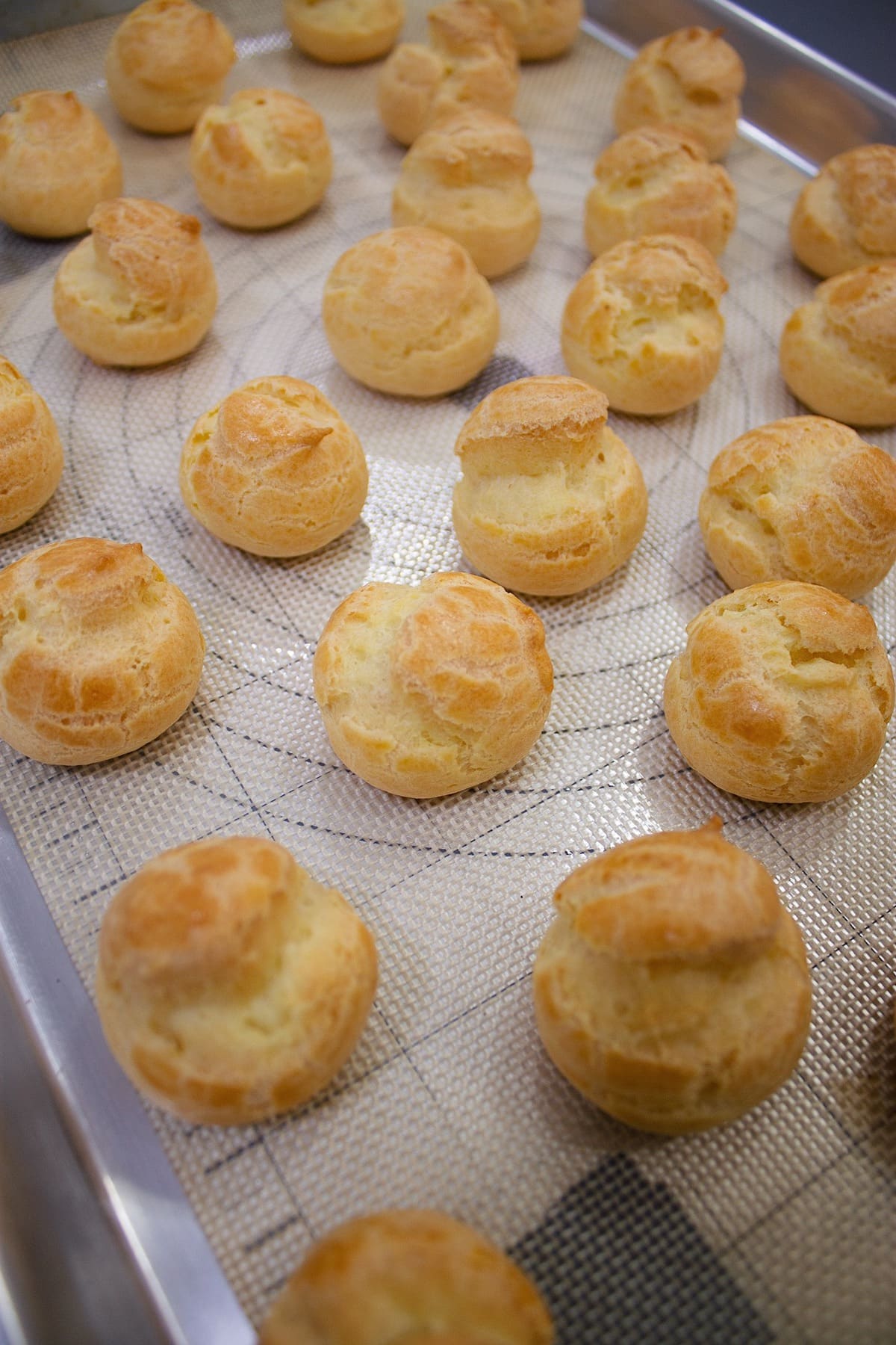Baked cream puffs on a sheet tray