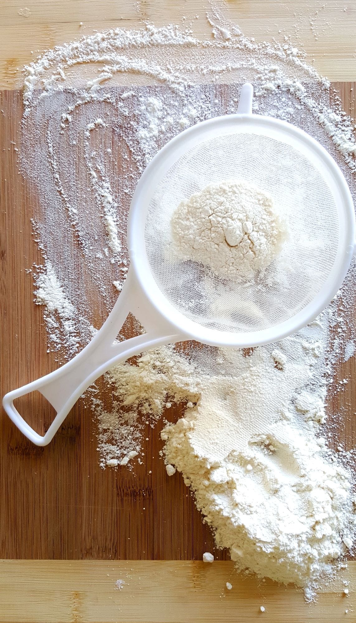 Sifter with flour on a cutting board 