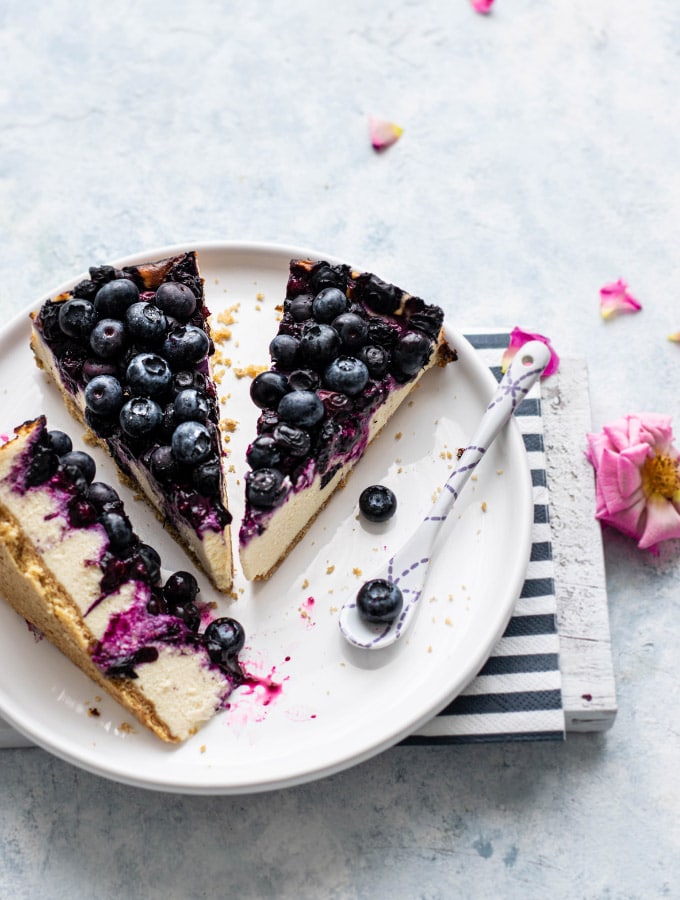 Three slices of blueberry cheesecake on a plate
