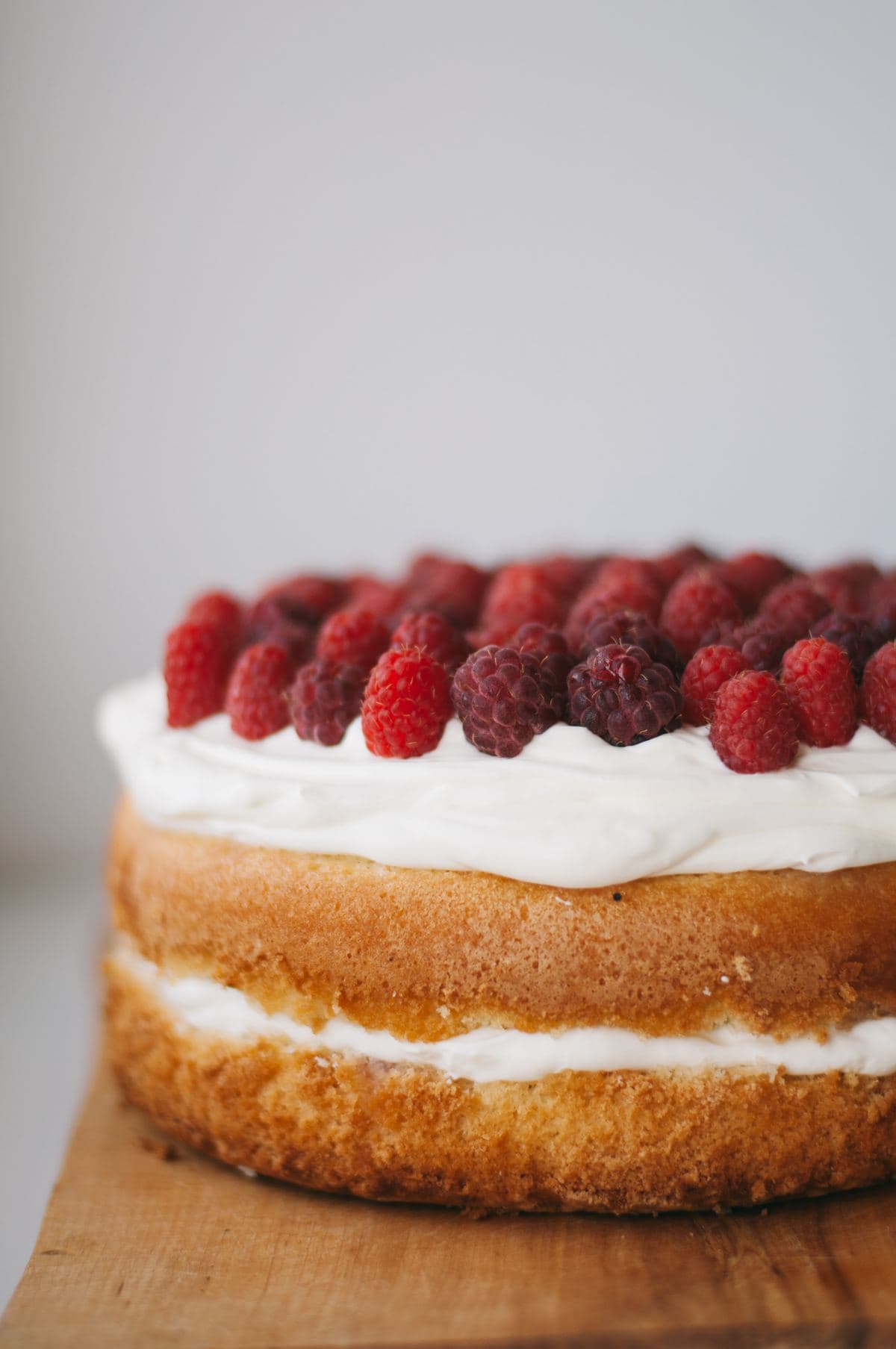 Sandwich cake topped with whipped cream and raspberries