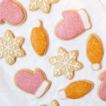Pink, orange, and white Christmas cookies on parchment paper
