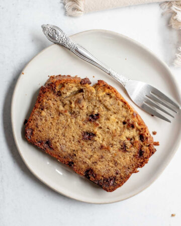 Slices of banana bread on a plate with a fork resting on it