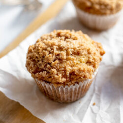 Banana crumb muffins on a cutting board with parchment paper
