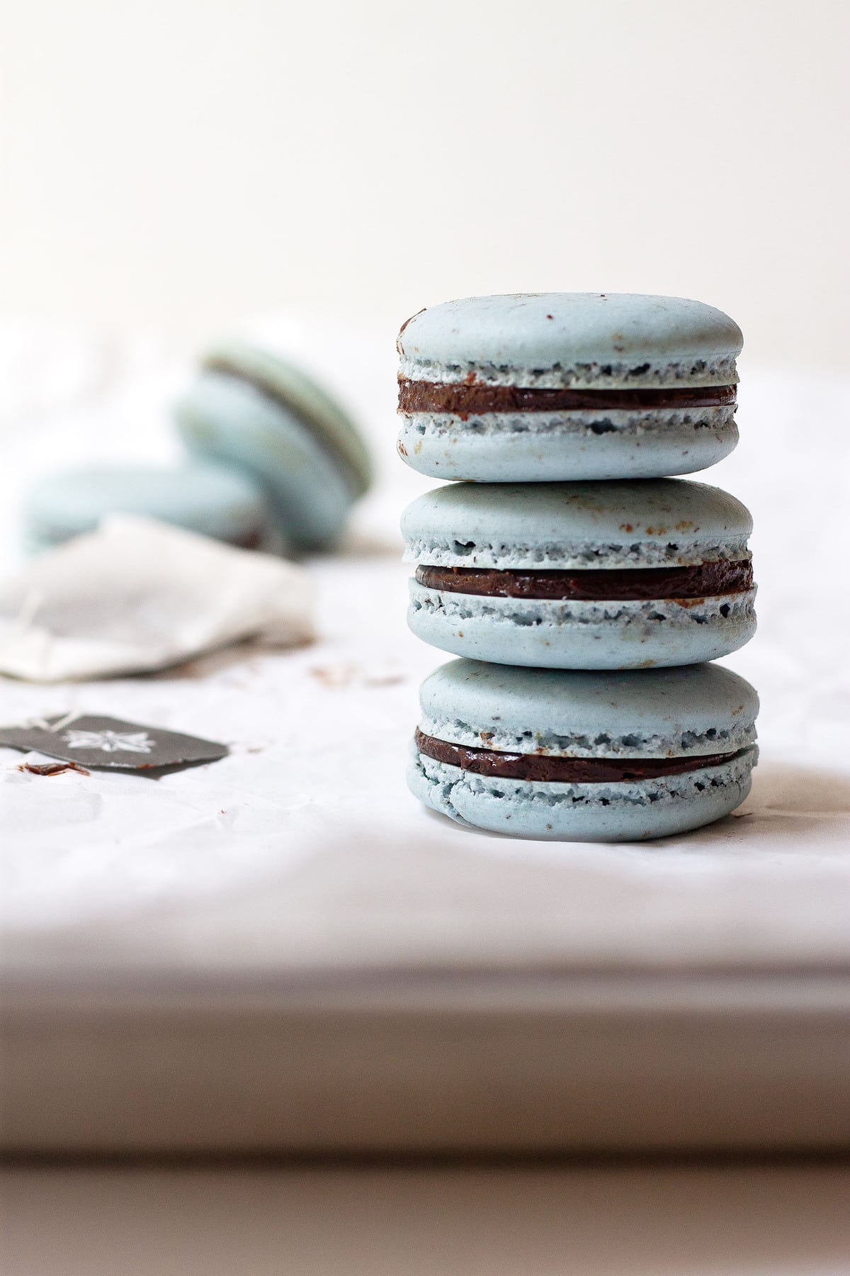 Stack of earl grey macarons on top of a baking sheet