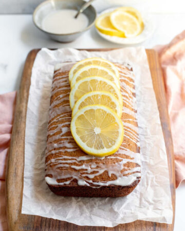 Earl Grey and lemon loaf cake on a cutting board lined with parchment paper