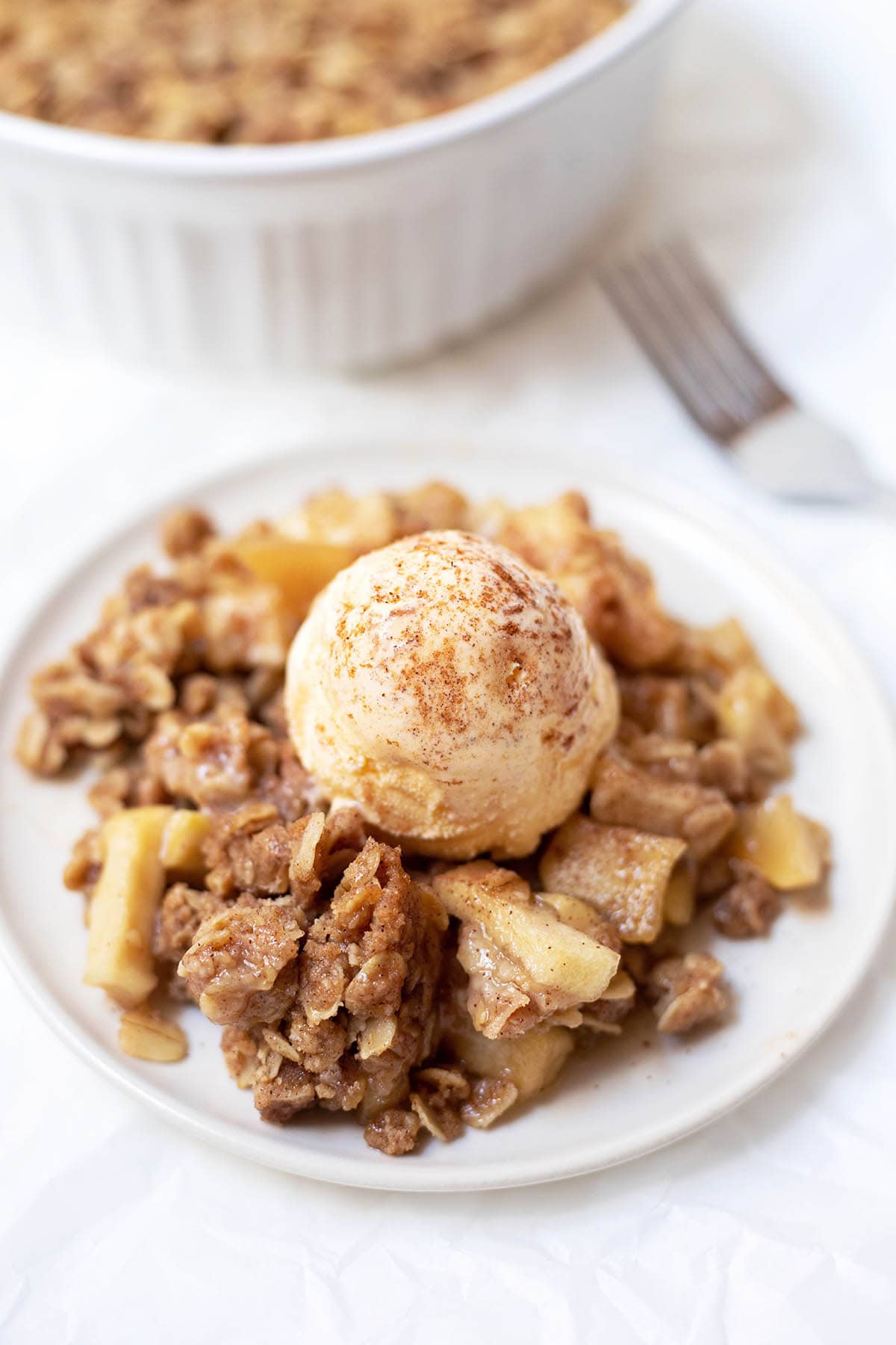Plate of apple crisp topped with vanilla ice cream 