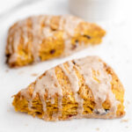 Two pumpkin cranberry scones on parchment paper