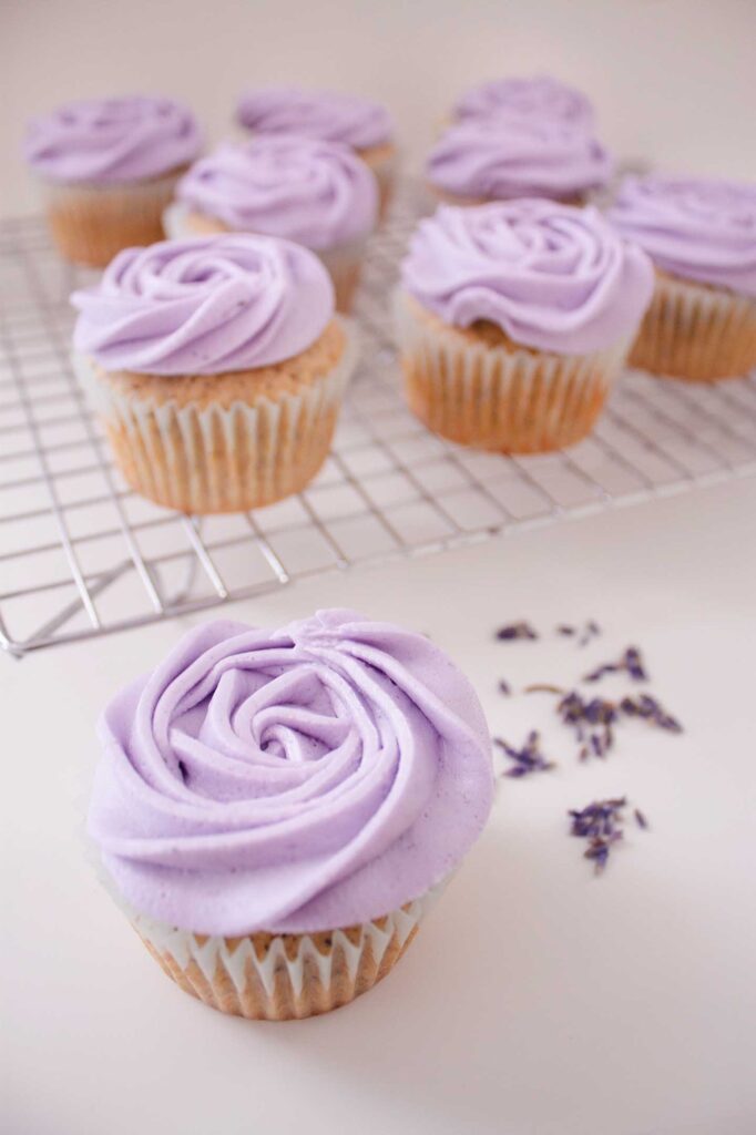 Earl grey and lavender cupcake with lavender sprinkled behind it