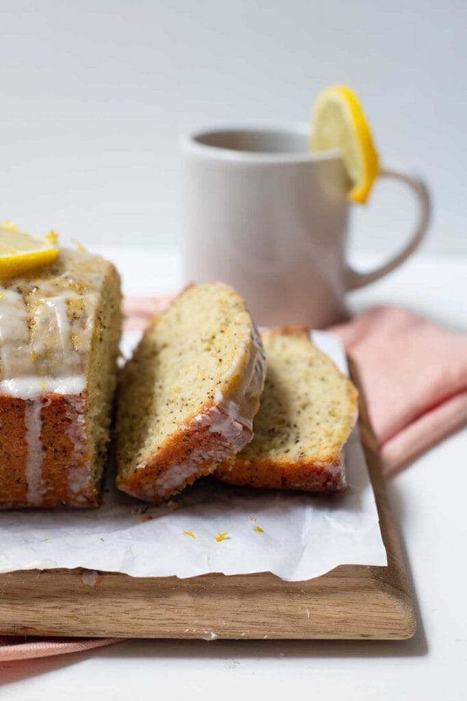 Earl grey and lemon loaf cake on a cutting board with slices falling down