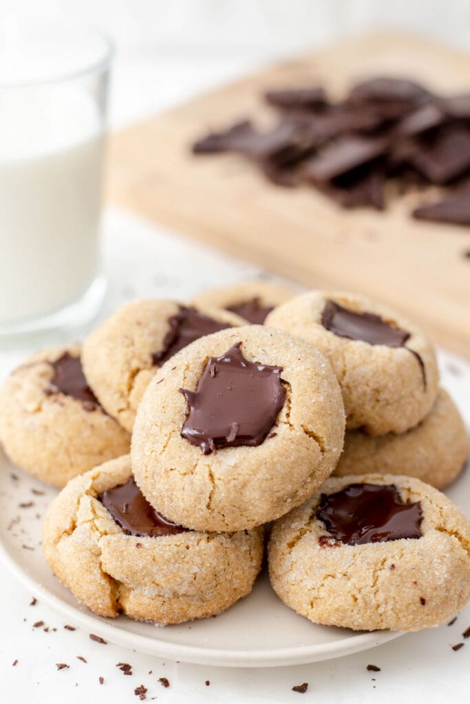 Vegan peanut butter blossoms next to a glass of milk