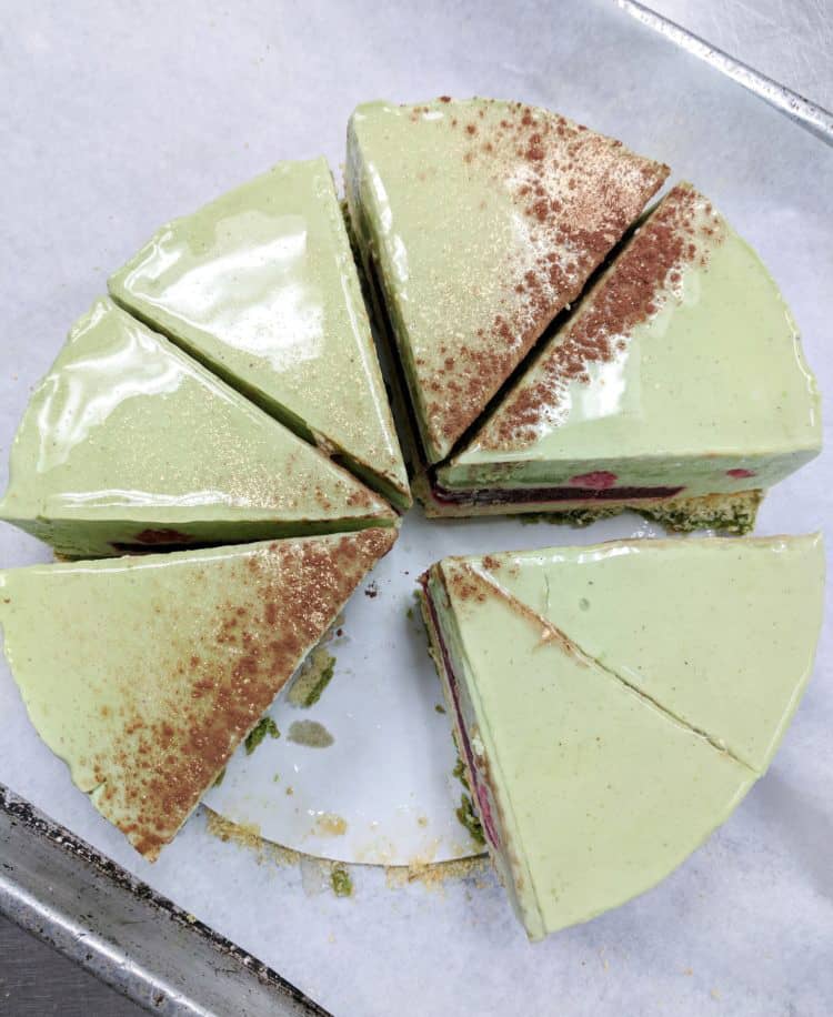 Pistachio raspberry entremet on a cake board 