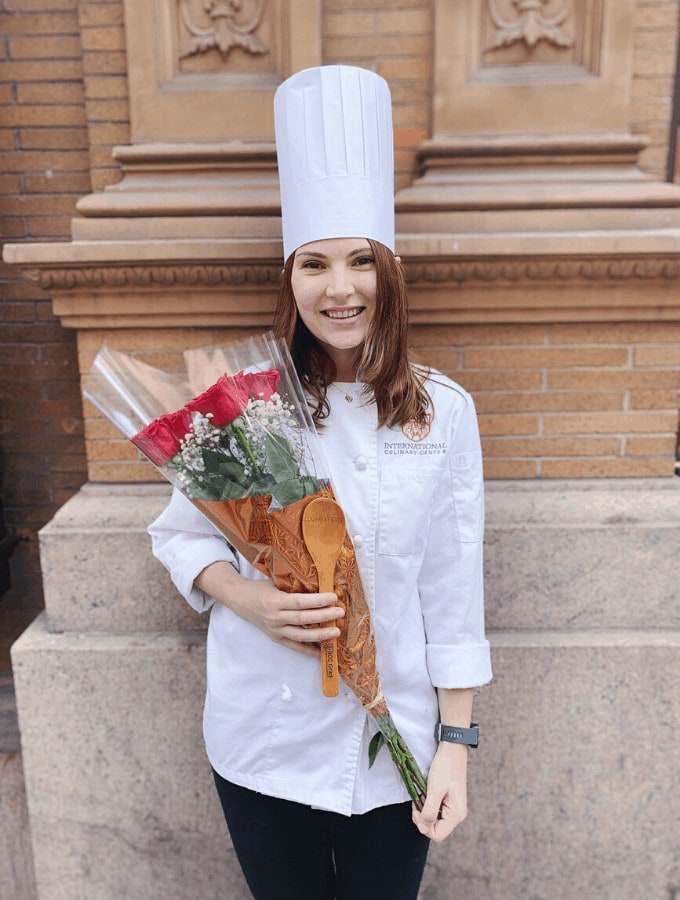 Leslie Jeon in chef's whites and hat holding roses