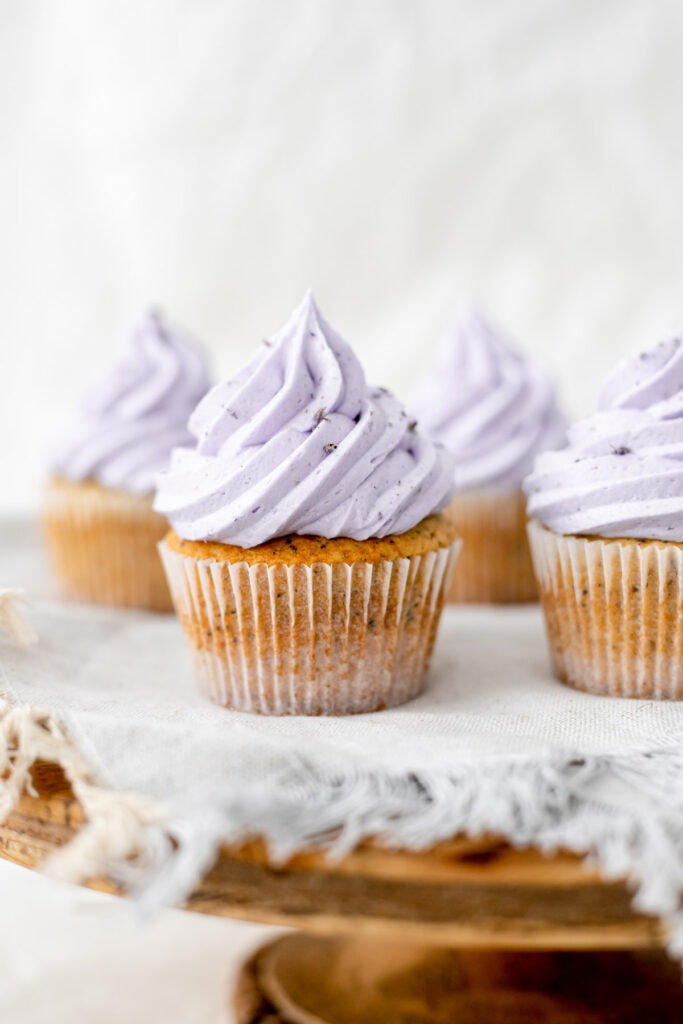 Cake stand topped with Earl Grey lavender cupcakes on a grey napkin