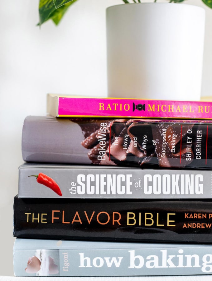 Stack of baking books resting underneath a plant