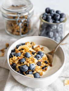 Bowl of yogurt with blueberry granola and blueberries on top