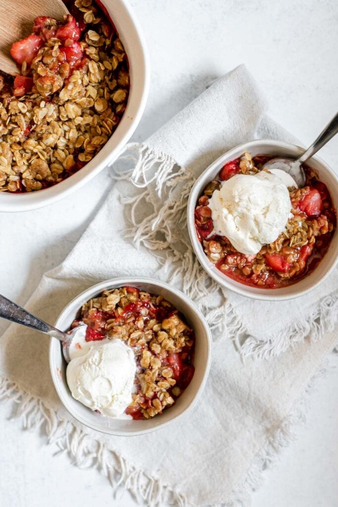 Overhead shot of two bowls of strawberry cardamom crisp 