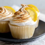 Three lemon meringue cupcakes on a plate