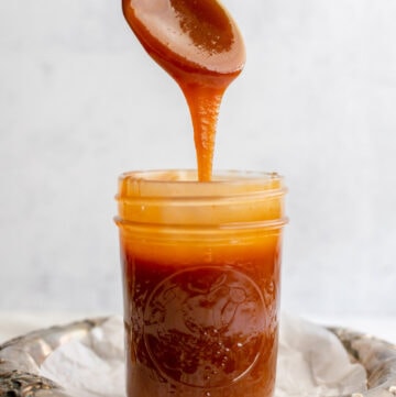 Spoon dripping into a pot of caramel sauce