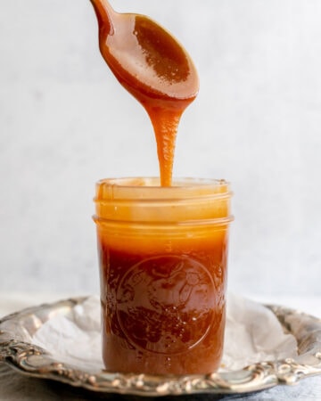 Spoon dripping into a pot of caramel sauce