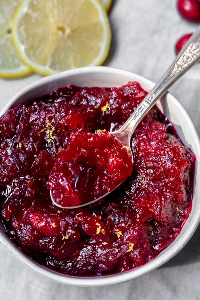 Bowl of cranberry sauce with spoon resting on top