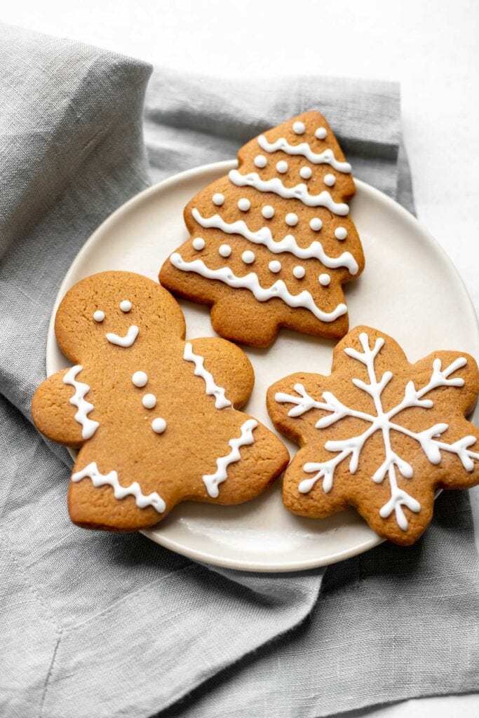Plate of three gingerbread cookies on top of a grey napkin