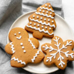 Plate of three gingerbread cookies on top of a grey napkin