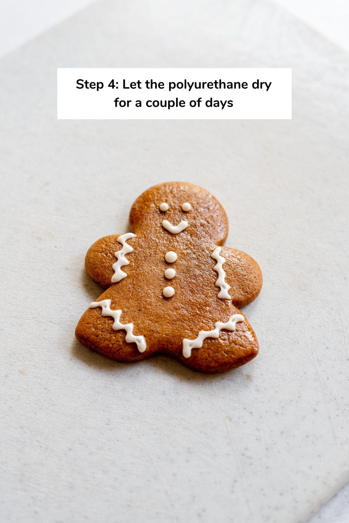 Photo of gingerbread cookie that reads 'Step 4: Let the polyurethane dry for a couple of days'