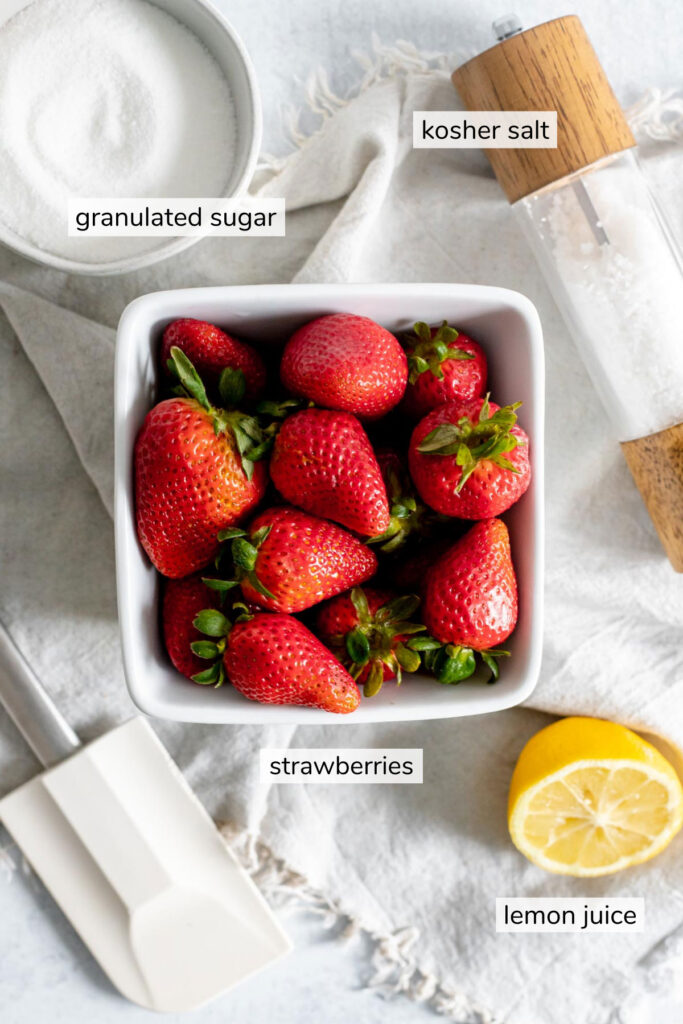 Labeled ingredients for strawberry jam - granulated sugar, kosher salt, strawberries, lemon juice