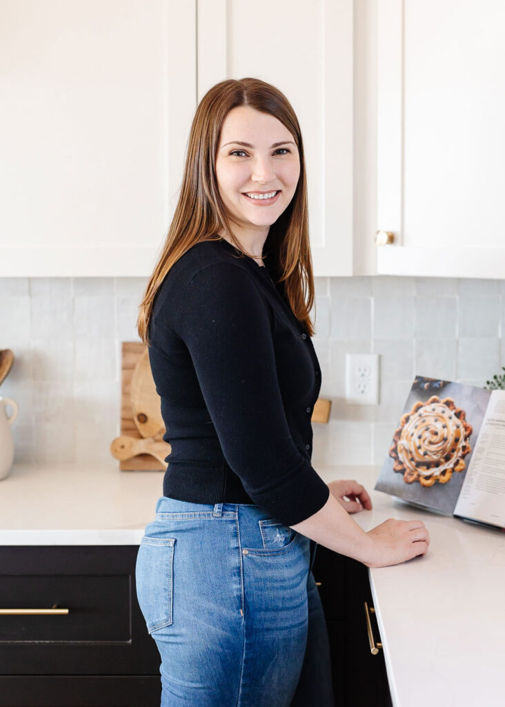 Leslie Jeon standing in front of a cookbook