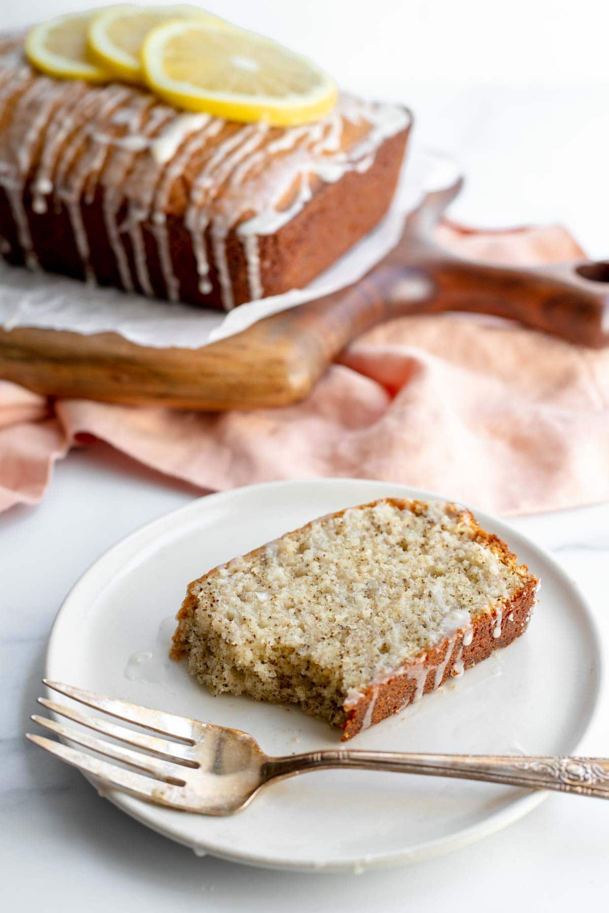 Slice of earl grey and lemon loaf cake on a plate with a fork 
