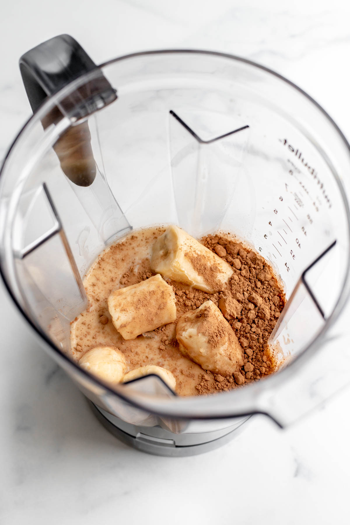 Bananas, milk, and cocoa powder in a blender