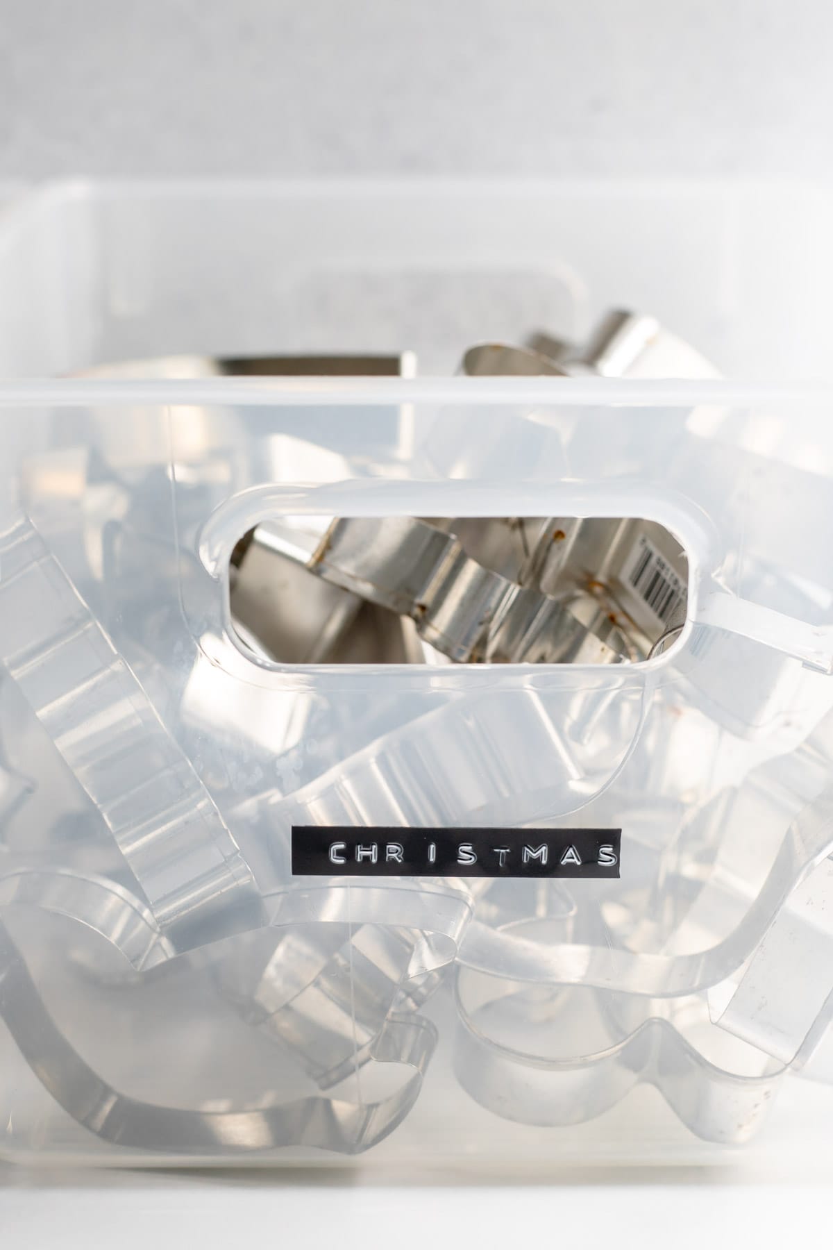 Clear bin of cookie cutters labeled 'Christmas'