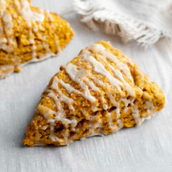 Pumpkin scones on parchment paper in front of a napkin